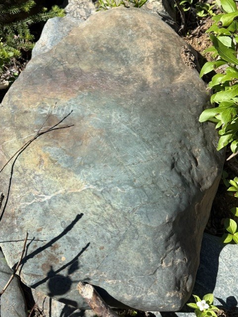 A large weathered nephrite boulder at the property, showing natural green-grey colouring.
